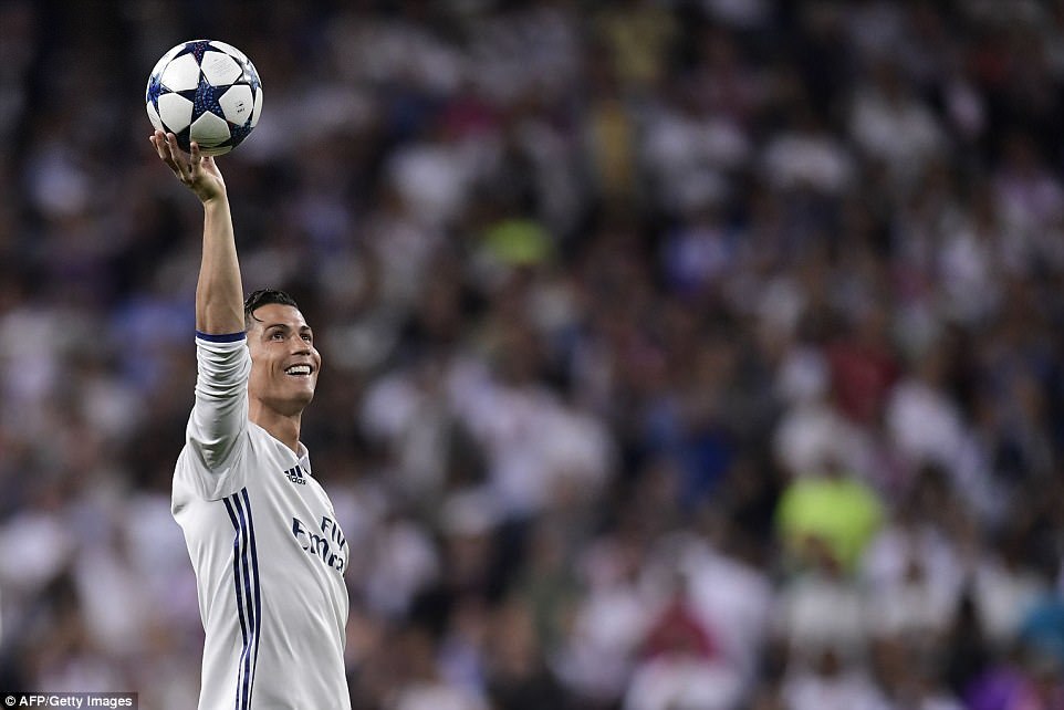 Ronaldo holds the match ball aloft after his hat-trick sent Bayern crashing out of the Champions League