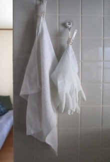 キッチンの壁に白いタオルと炊事用手袋